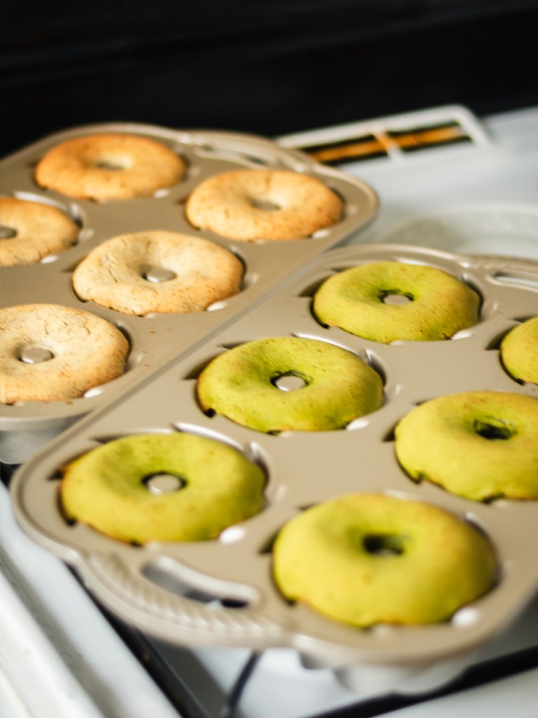 one dozen freshly baked matcha mochi mini bundt cakes resting on a stovetop 
